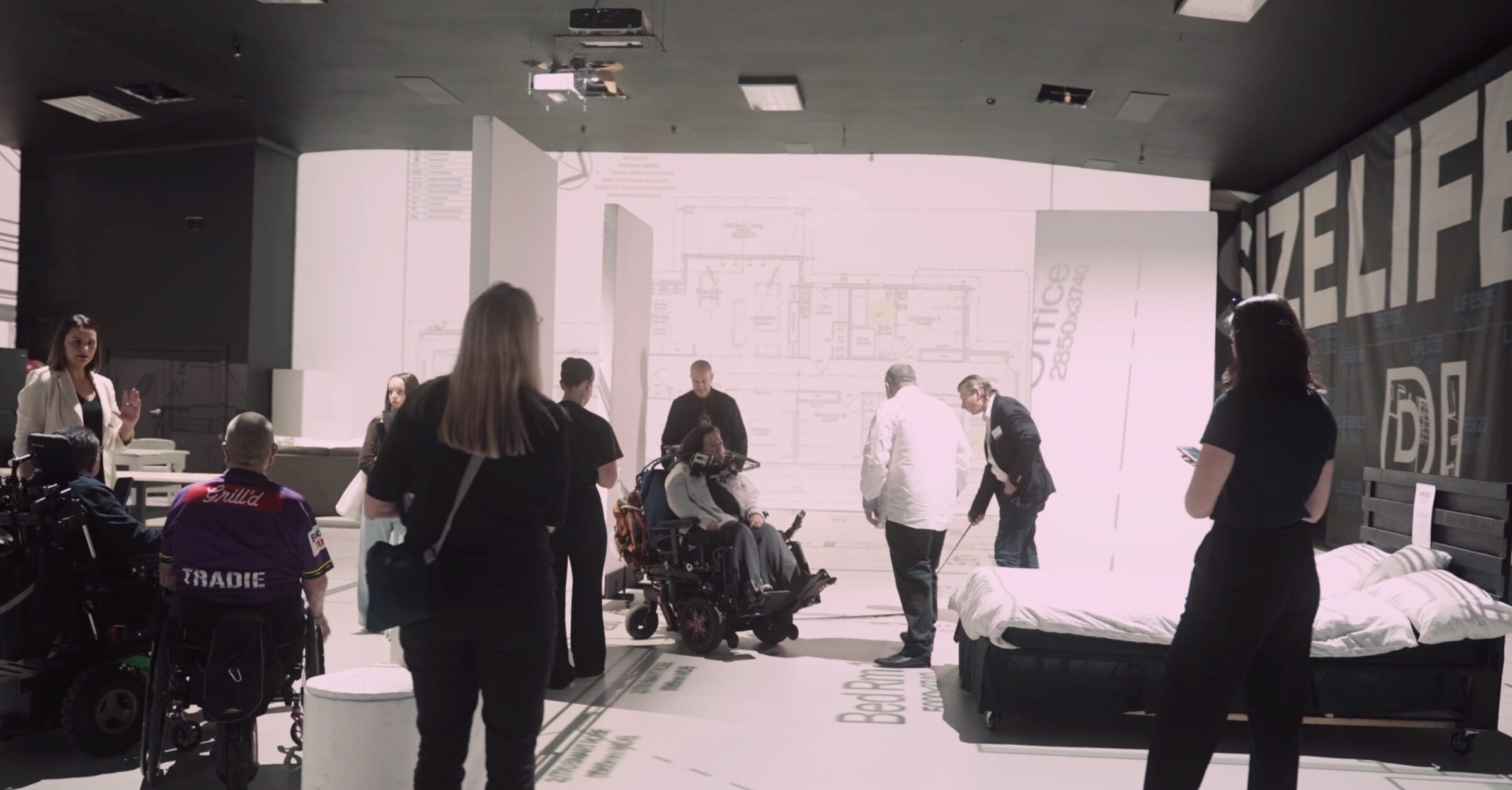 Participants, families, Occupational Therapists and support teams walking through a full-scale SDA floor plan at Lifesize Plans in Burwood