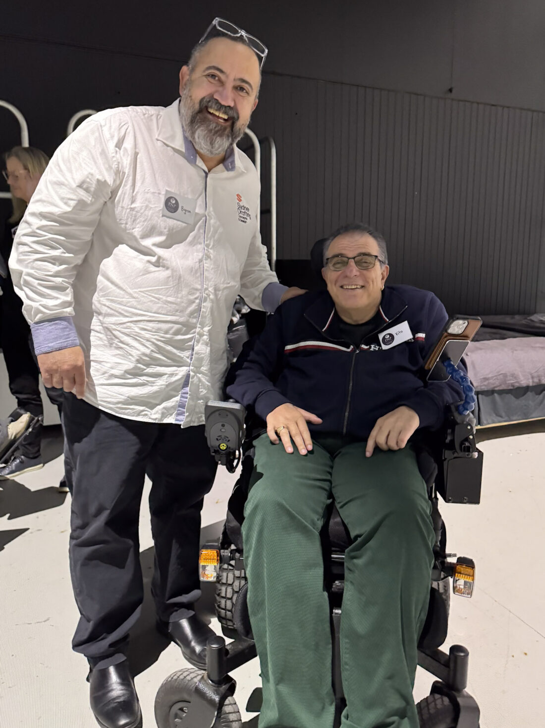 A designer from Sydney Drafting Concepts and Design standing beside a smiling wheelchair user at the Macquarie Fields SDA walkthrough
