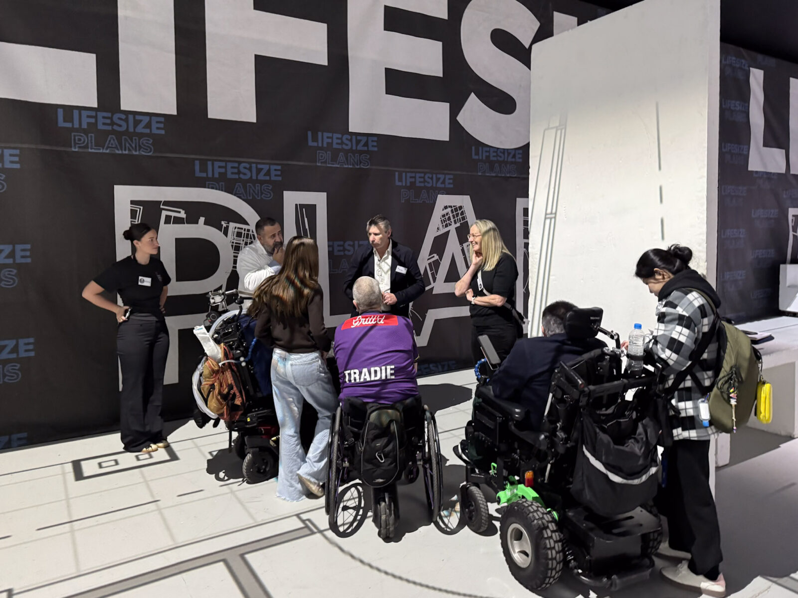 Participants, families, designers and support teams gathered on the projected floor plan at Lifesize Plans Burwood for the Macquarie Fields SDA walkthrough